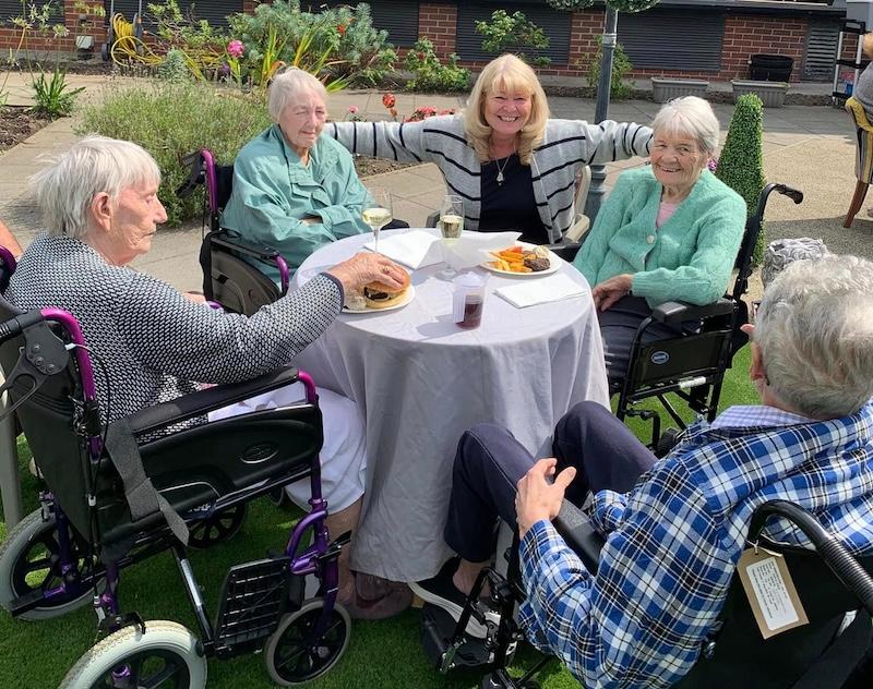 our residents sat outside in the garden together smiling