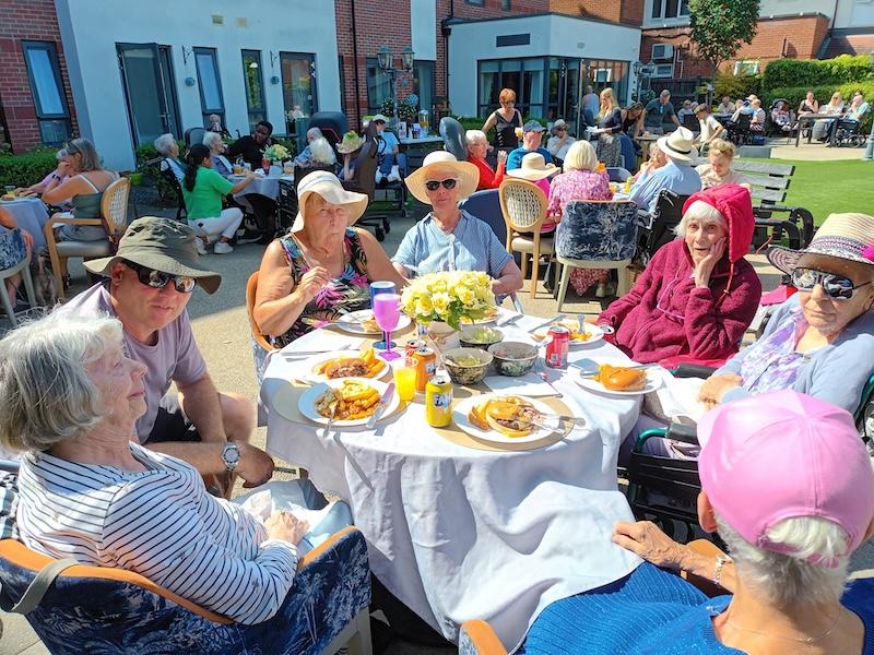 a group photo of residents eating bbq food