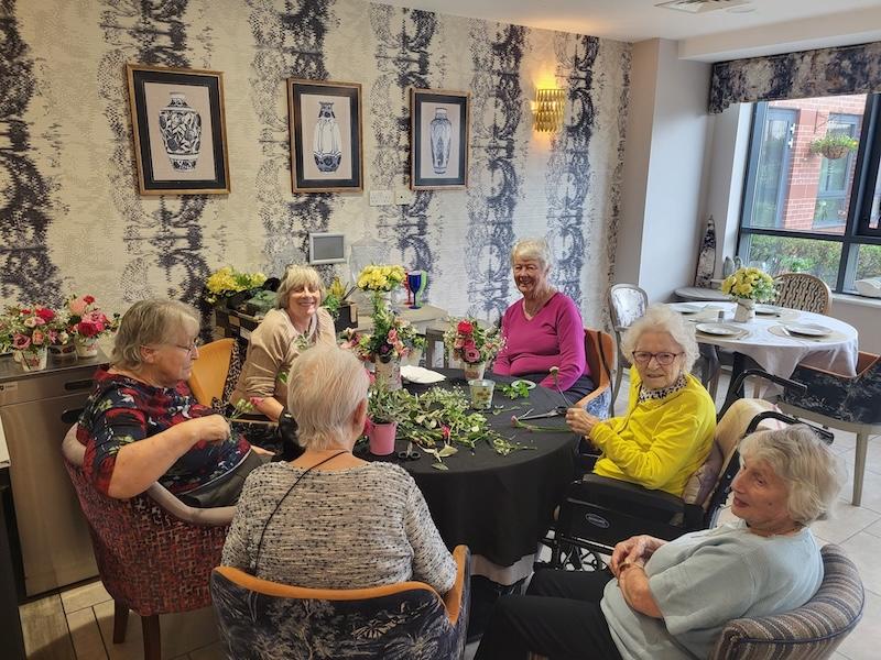 residents doing flower arranging together around the table