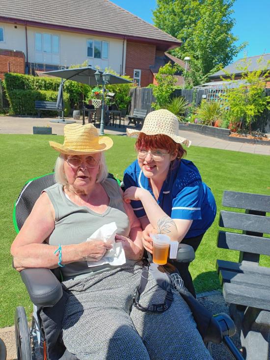 resident with a carer outside in the garden