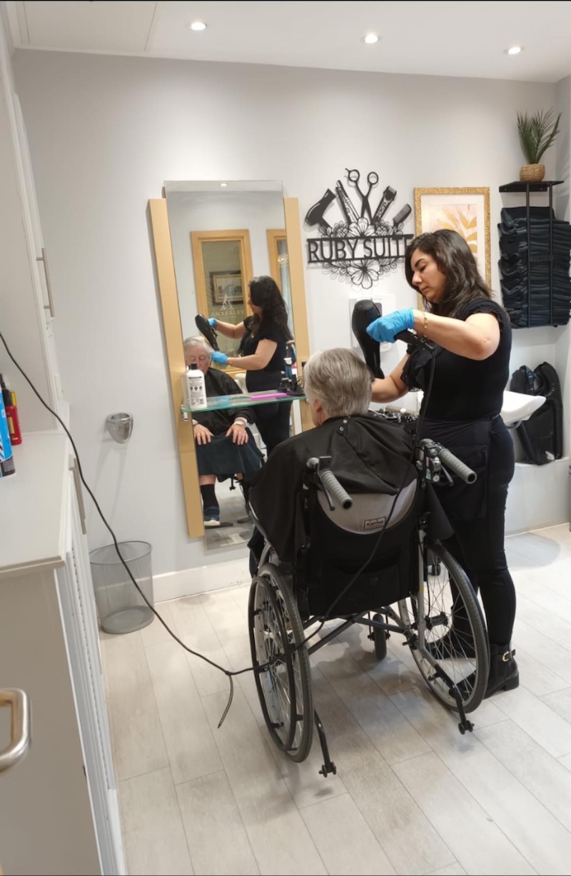 older lady sat in a wheelchair in a hair salon