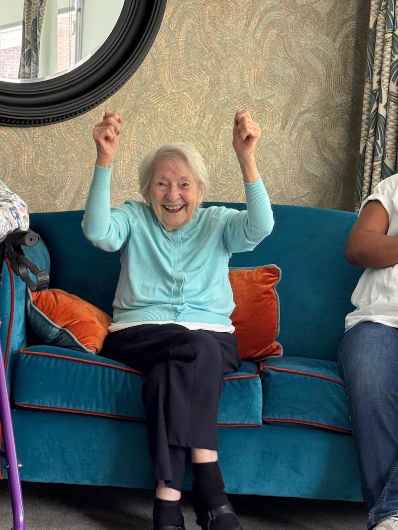 an older lady sat down with her hands up