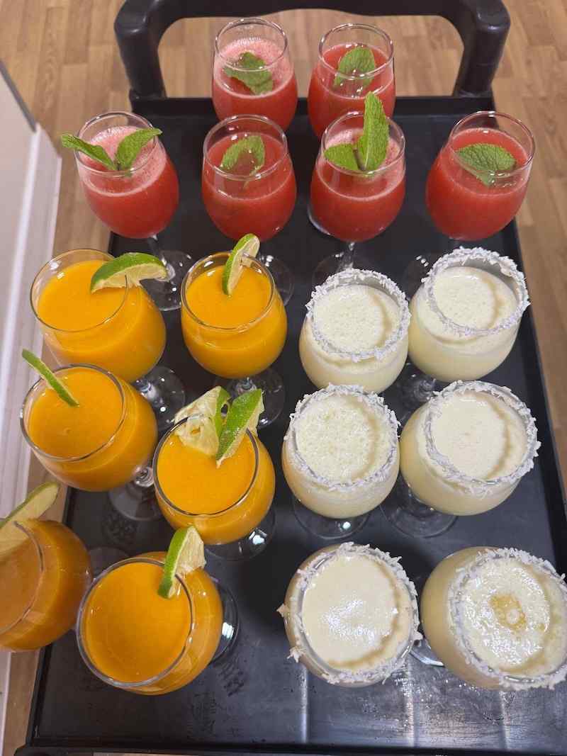 mango, coconut and strawberry smoothies on a tray