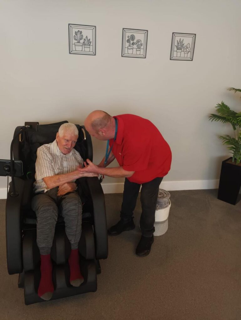 staff member with an older man sat down