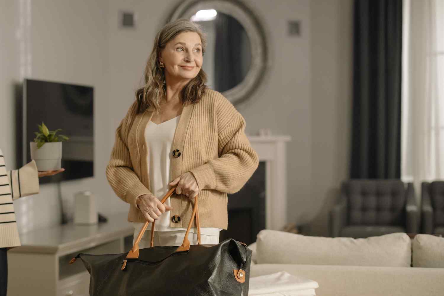older woman smiling holding a bag